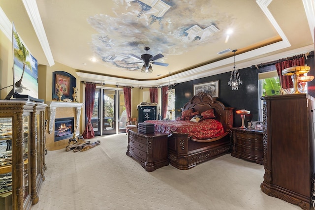 carpeted bedroom featuring access to exterior, french doors, a tray ceiling, ceiling fan, and crown molding