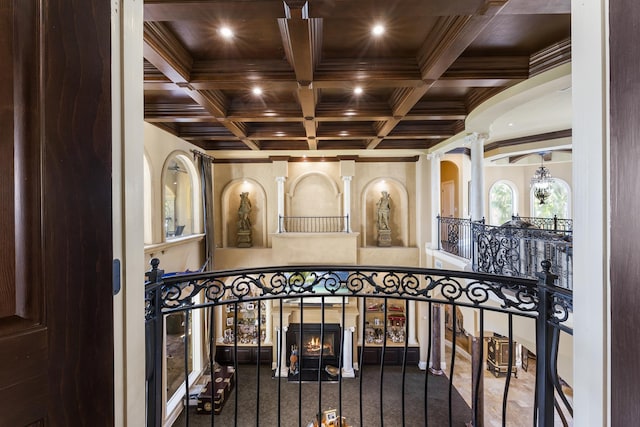 interior space with beamed ceiling, carpet, decorative columns, and coffered ceiling