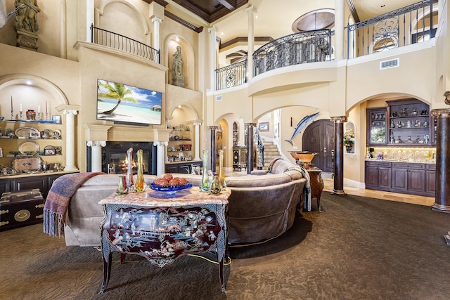 living room with bar area, a towering ceiling, carpet floors, and ornamental molding