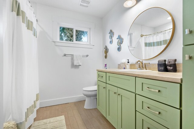 7201 A1A S, Saint Augustine, FL 32080 - bathroom with vanity, baseboards, toilet, visible vents, and wood finished floors