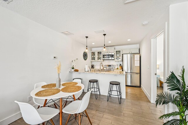 7201 A1A S, Saint Augustine, FL 32080 - dining space featuring baseboards, light wood-type flooring, recessed lighting, a textured ceiling, and visible vents