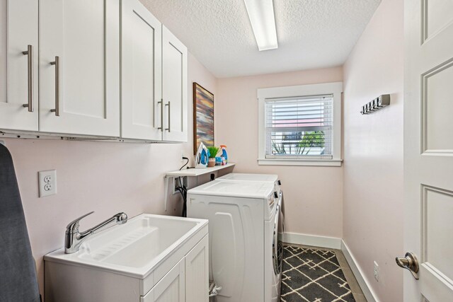 7201 A1A S, Saint Augustine, FL 32080 - clothes washing area with a textured ceiling, a sink, washer and dryer, baseboards, and cabinet space