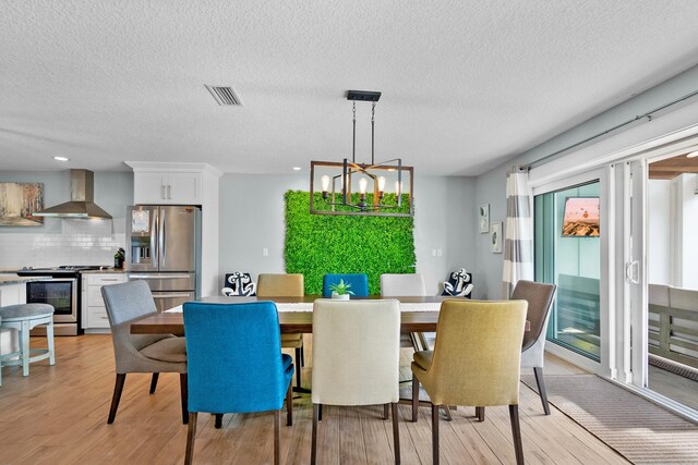 7201 A1A S, Saint Augustine, FL 32080 - dining room featuring visible vents, light wood-style flooring, a notable chandelier, and a textured ceiling