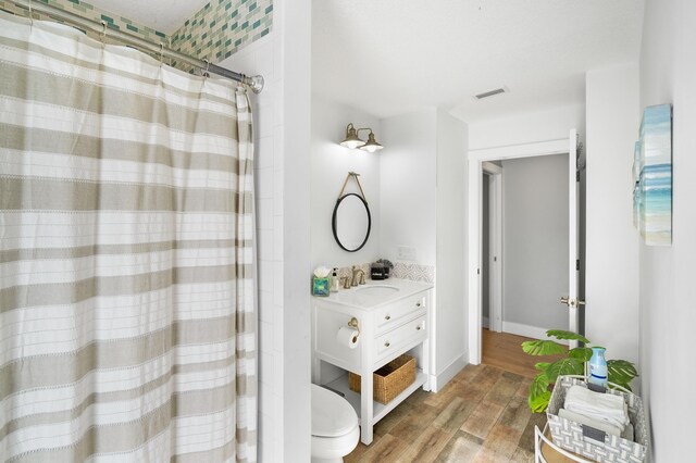 7201 A1A S, Saint Augustine, FL 32080 - bathroom featuring vanity, a shower with curtain, toilet, visible vents, and wood finished floors