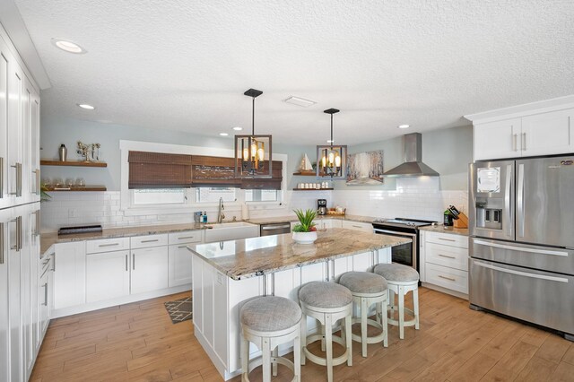 7201 A1A S, Saint Augustine, FL 32080 - kitchen featuring wall chimney range hood, open shelves, a chandelier, appliances with stainless steel finishes, and a sink
