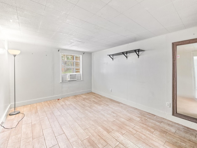 unfurnished room with cooling unit and light wood-type flooring