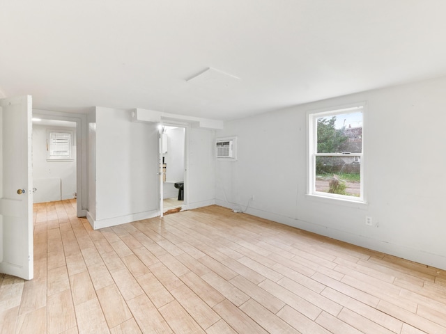 empty room featuring light hardwood / wood-style floors and a wall mounted AC