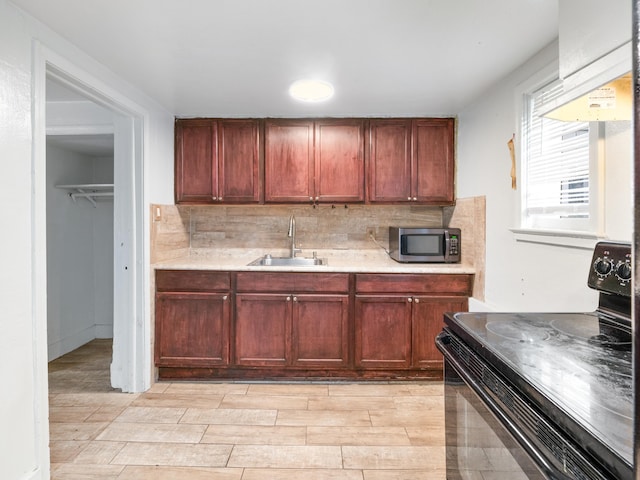 kitchen with sink, black electric range oven, range hood, light hardwood / wood-style floors, and decorative backsplash