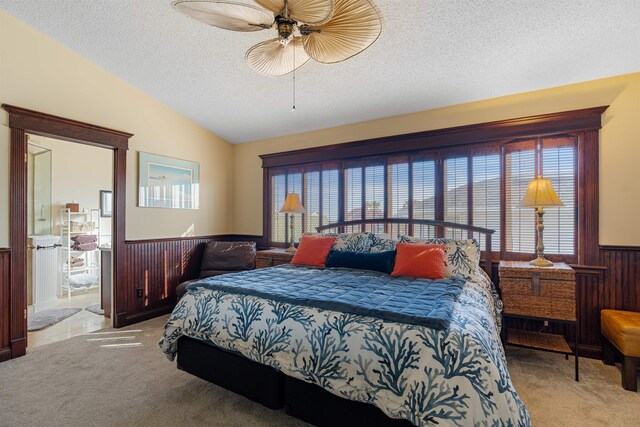 2900 Coastal Hwy, Saint Augustine, FL 32084 - carpeted bedroom featuring wood walls, a textured ceiling, ceiling fan, a wainscoted wall, and lofted ceiling