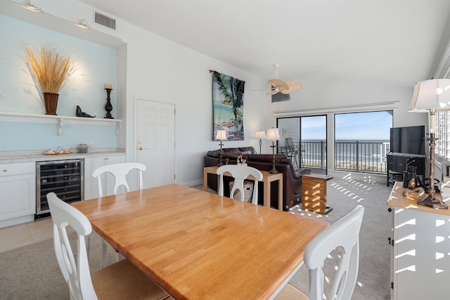 2900 Coastal Hwy, Saint Augustine, FL 32084 - dining area featuring a dry bar, wine cooler, visible vents, light colored carpet, and lofted ceiling