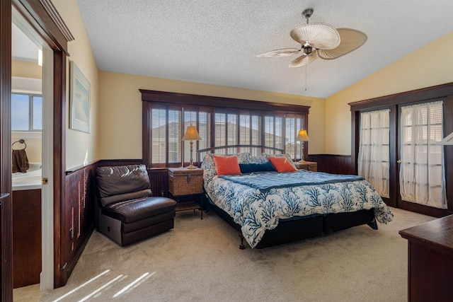 2900 Coastal Hwy, Saint Augustine, FL 32084 - bedroom featuring a wainscoted wall, vaulted ceiling, a textured ceiling, light colored carpet, and ceiling fan