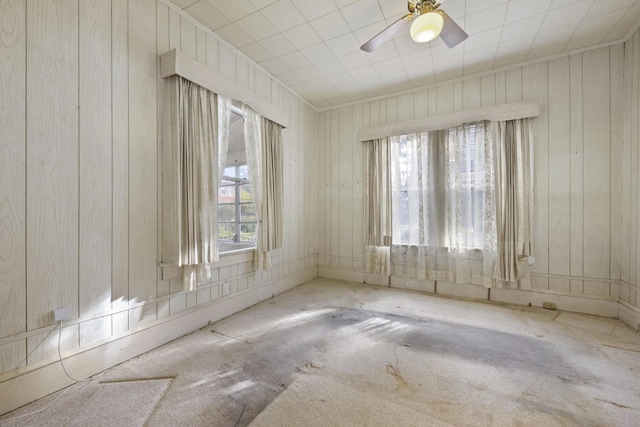 spare room featuring wood walls and ceiling fan