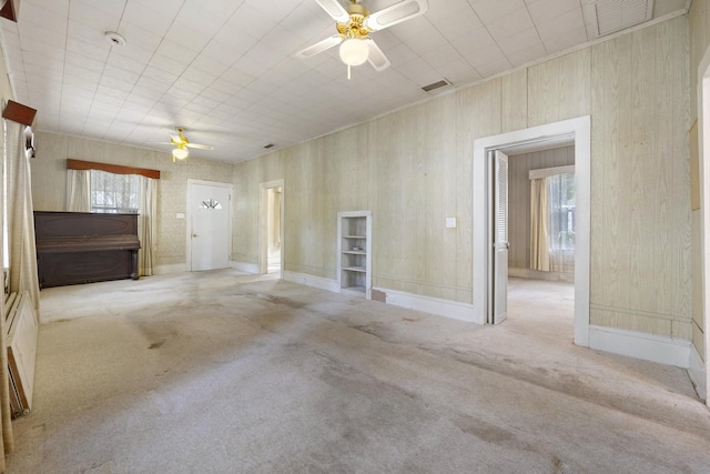 carpeted empty room featuring a wealth of natural light and ceiling fan