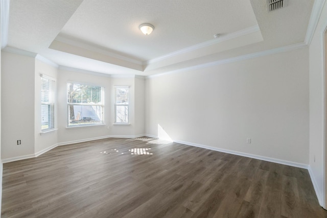 spare room with ornamental molding, dark hardwood / wood-style floors, and a raised ceiling