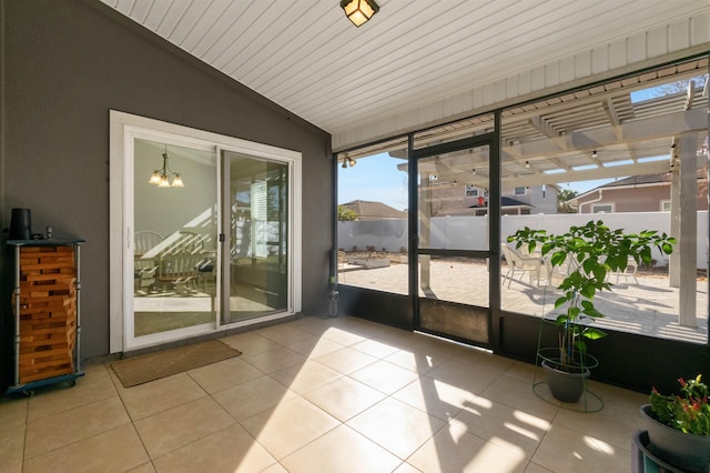 unfurnished sunroom featuring vaulted ceiling and a notable chandelier