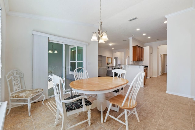 tiled dining room with ornamental molding and a notable chandelier