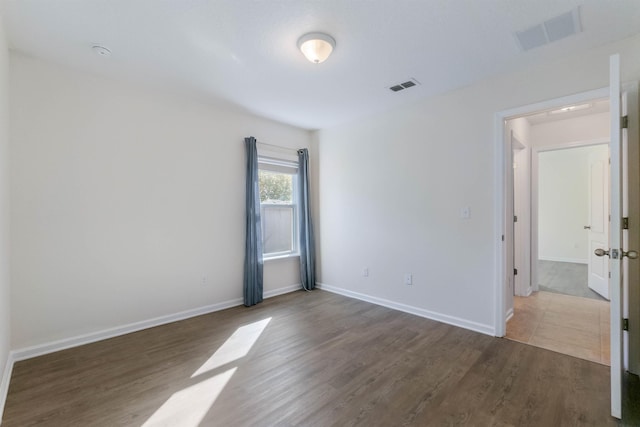 spare room featuring wood-type flooring