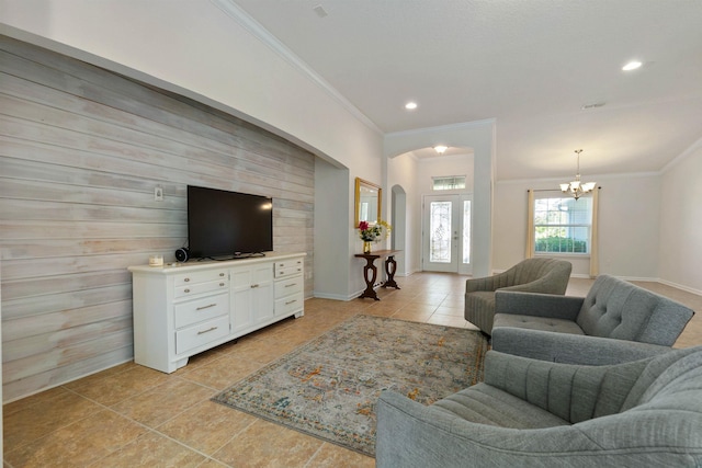 living room with crown molding, a notable chandelier, and light tile patterned floors