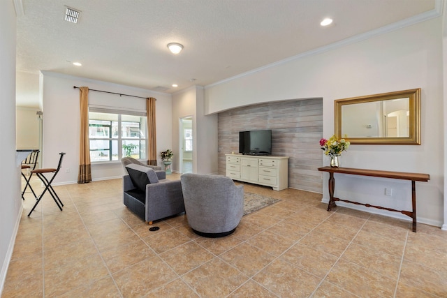 tiled living room featuring ornamental molding and a textured ceiling