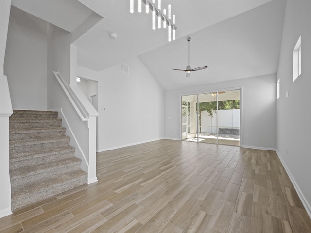 unfurnished living room featuring high vaulted ceiling, light hardwood / wood-style flooring, and ceiling fan