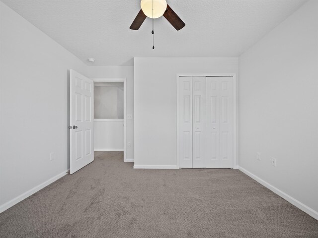 unfurnished bedroom featuring a textured ceiling, ceiling fan, light carpet, and a closet