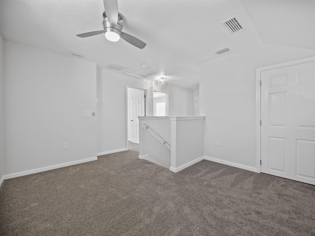 carpeted empty room featuring a textured ceiling, ceiling fan, and lofted ceiling