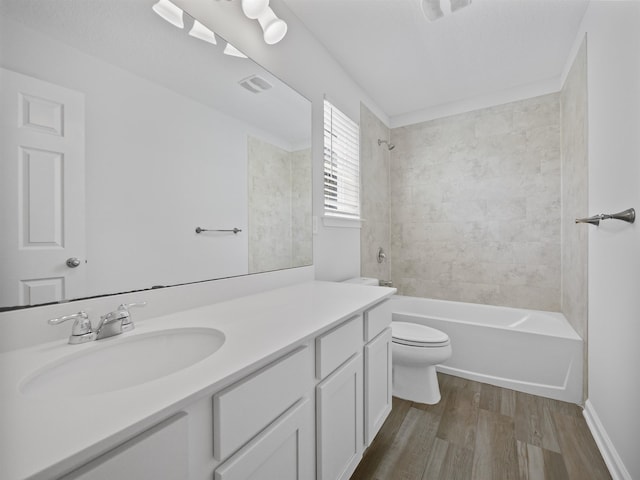 full bathroom featuring hardwood / wood-style flooring, vanity, toilet, and tiled shower / bath