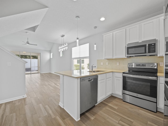 kitchen with white cabinets, ceiling fan, kitchen peninsula, and appliances with stainless steel finishes