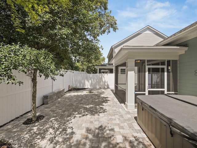 view of patio featuring a sunroom and a hot tub