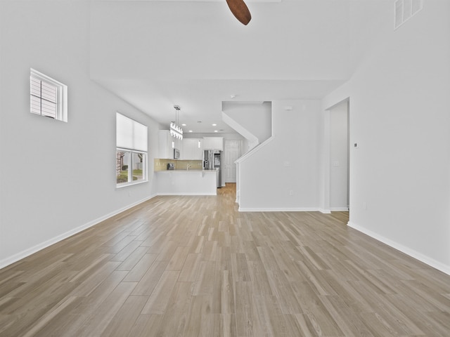 unfurnished living room featuring light hardwood / wood-style flooring and ceiling fan