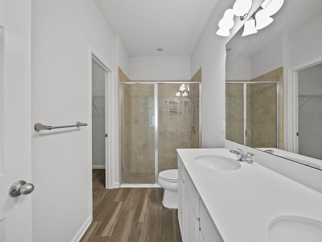 bathroom with hardwood / wood-style flooring, vanity, toilet, and an enclosed shower