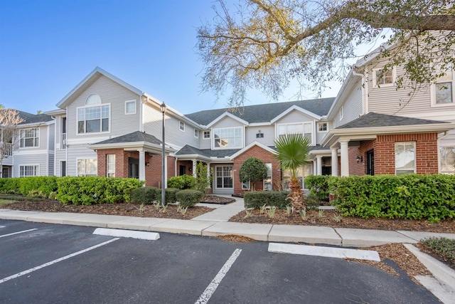 view of front of house with brick siding and uncovered parking