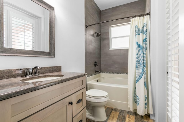 full bathroom featuring hardwood / wood-style floors, vanity, toilet, and shower / tub combo