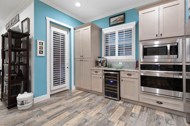 kitchen with stainless steel microwave, backsplash, crown molding, light wood-type flooring, and beverage cooler