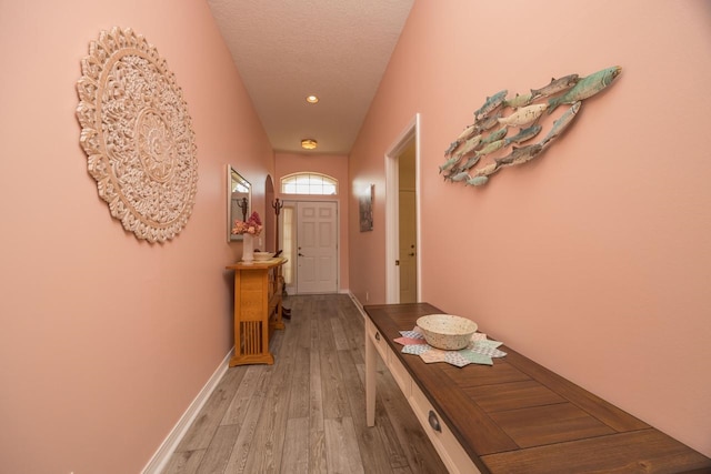 doorway with wood-type flooring and a textured ceiling