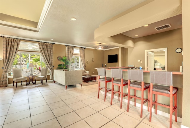 dining area with ceiling fan, light tile patterned flooring, a textured ceiling, and a wealth of natural light