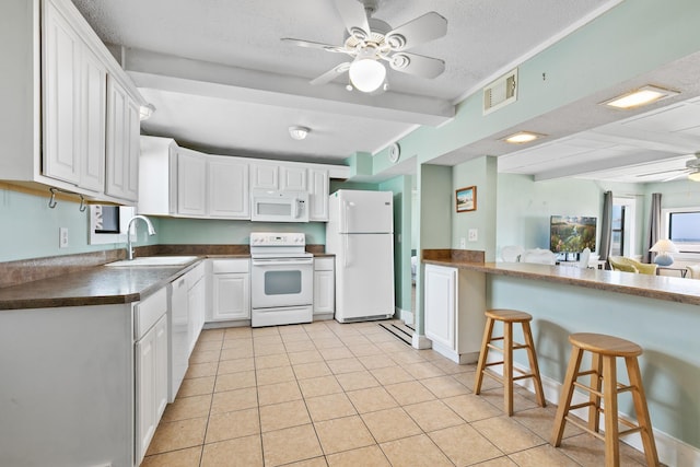 kitchen featuring visible vents, a sink, white appliances, a textured ceiling, and ceiling fan