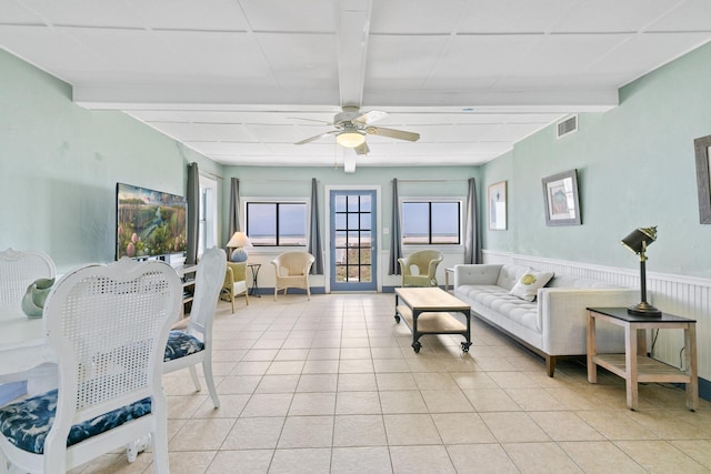 living room with beamed ceiling, visible vents, and light tile patterned floors