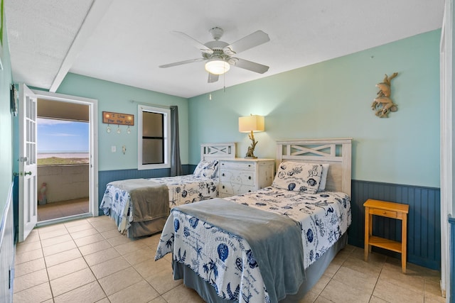 bedroom with wainscoting, ceiling fan, tile patterned flooring, and access to exterior