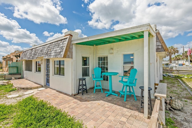 back of house with stucco siding, fence, and a patio area