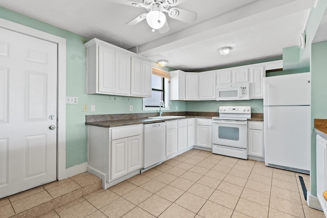 kitchen featuring white cabinets, a sink, dark countertops, a ceiling fan, and white appliances