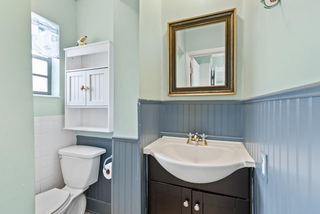 bathroom featuring wainscoting, vanity, and toilet