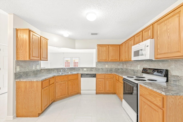 kitchen featuring tasteful backsplash, white appliances, sink, and a textured ceiling