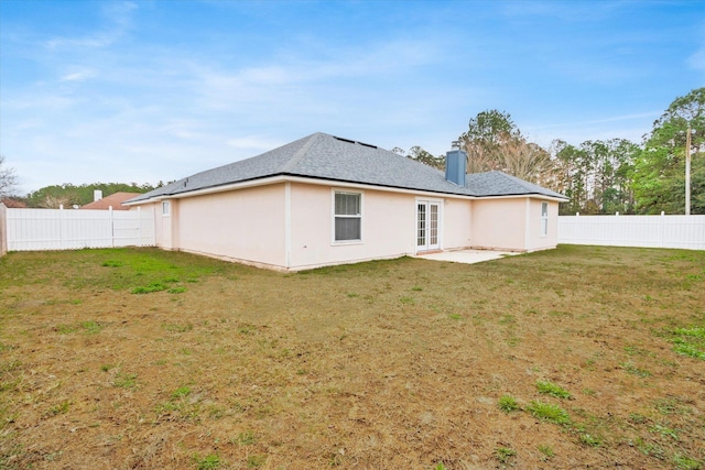 rear view of property featuring a lawn