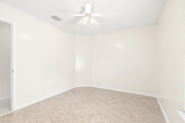 empty room with ceiling fan and a textured ceiling