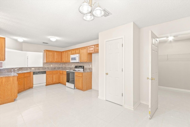 kitchen with sink, a textured ceiling, white appliances, and decorative backsplash