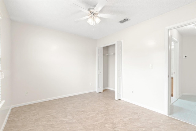 unfurnished bedroom with a textured ceiling, a closet, and ceiling fan