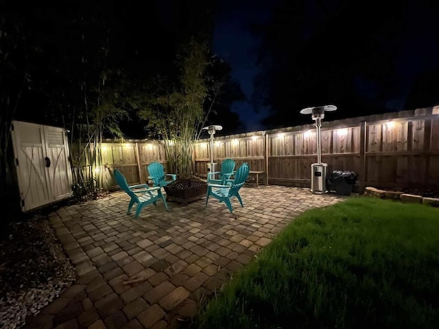 patio at twilight with a fire pit and fence