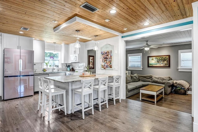 kitchen with a breakfast bar area, visible vents, appliances with stainless steel finishes, and a sink