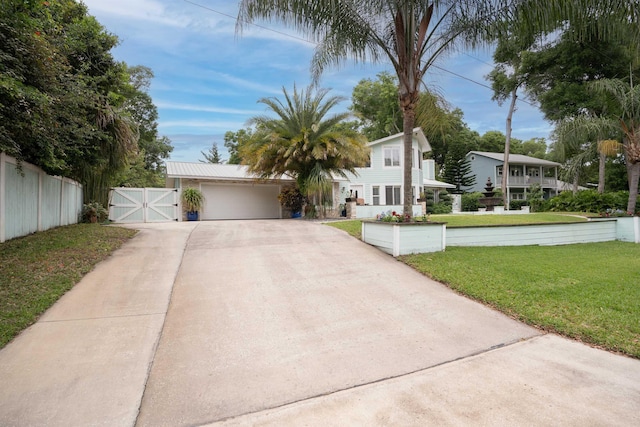 view of front of house with an attached garage, fence, driveway, a gate, and a front yard